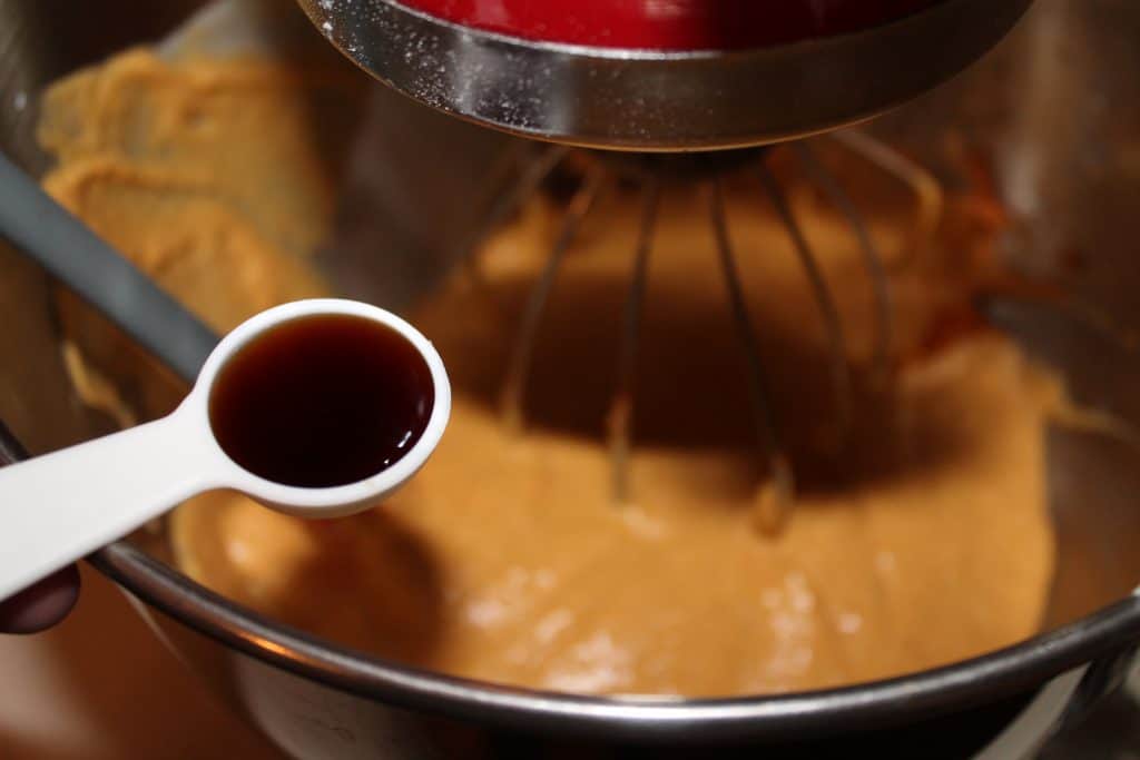 adding vanilla extract into the pumpkin mixture in the bowl