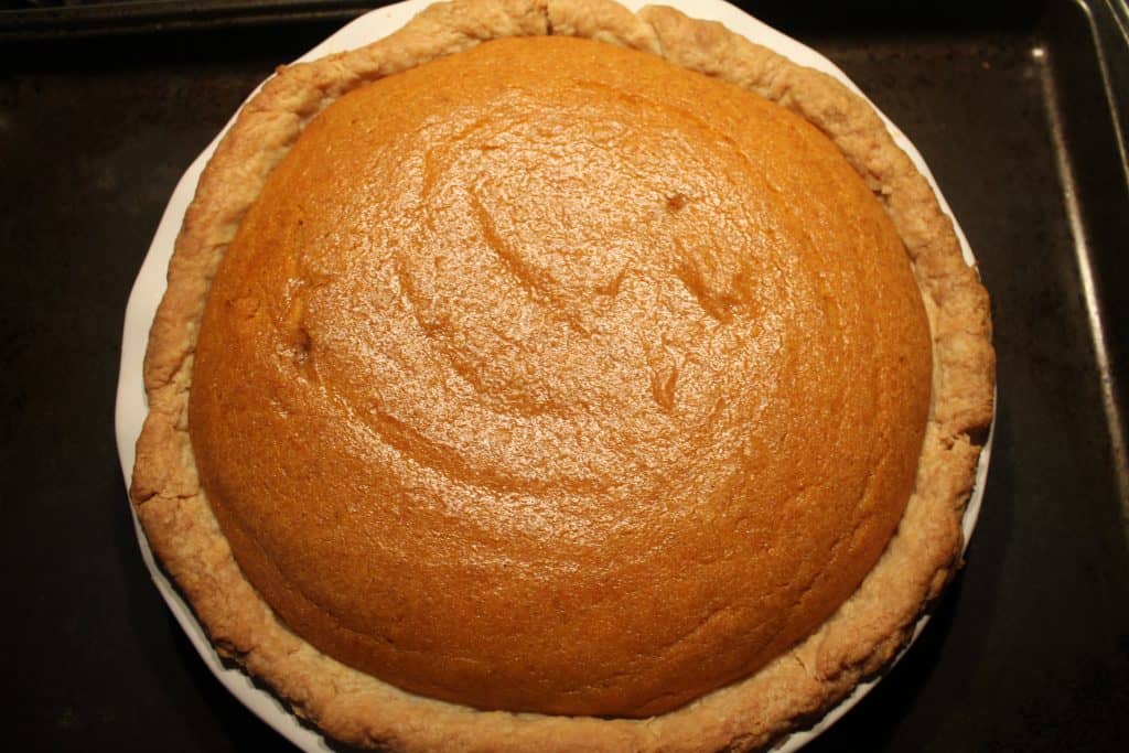 a baked pumpkin pie with golden edge on crust