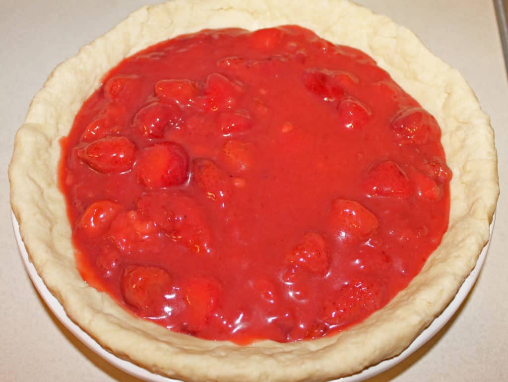 strawberry filling poured into an unbaked pie crust