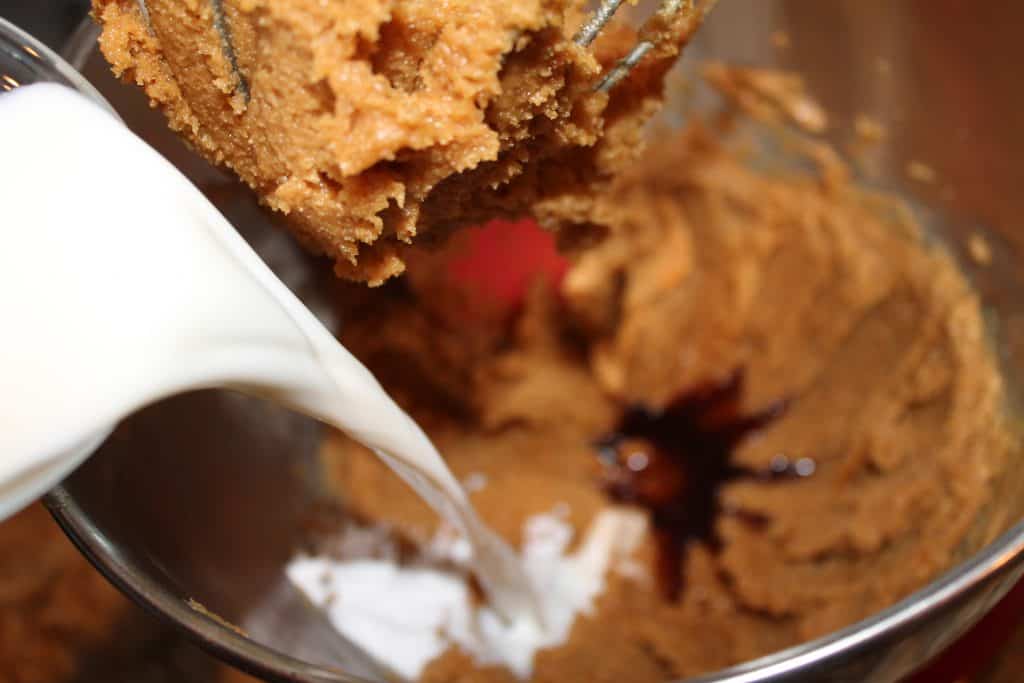 Adding milk, vanilla, and baking soda to the peanut butter mixture.