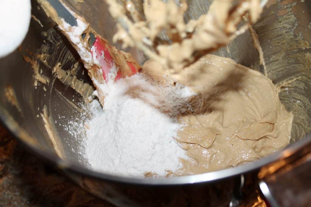 Adding flour to the mixing bowl.