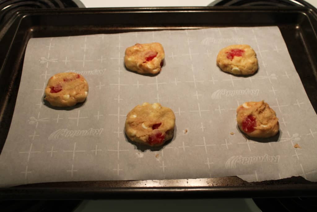 balls of cookie dough placed on a cookie sheet lined with parchment paper and flattened slightly with the palm of your hand to allow for even cooking
