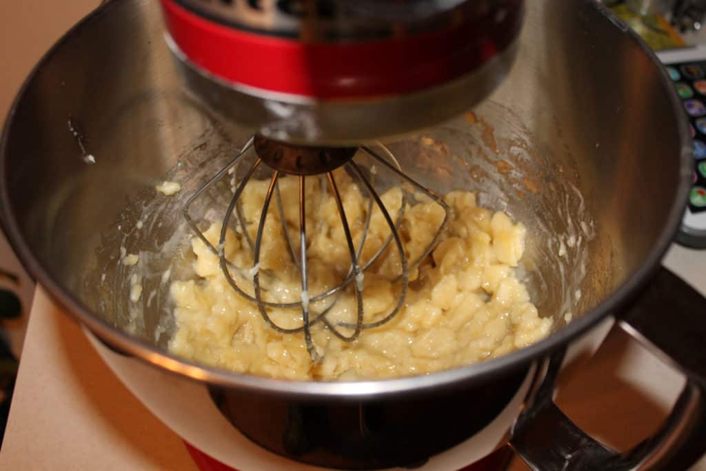 Bananas mashed with a whisk attachment in a mixing bowl