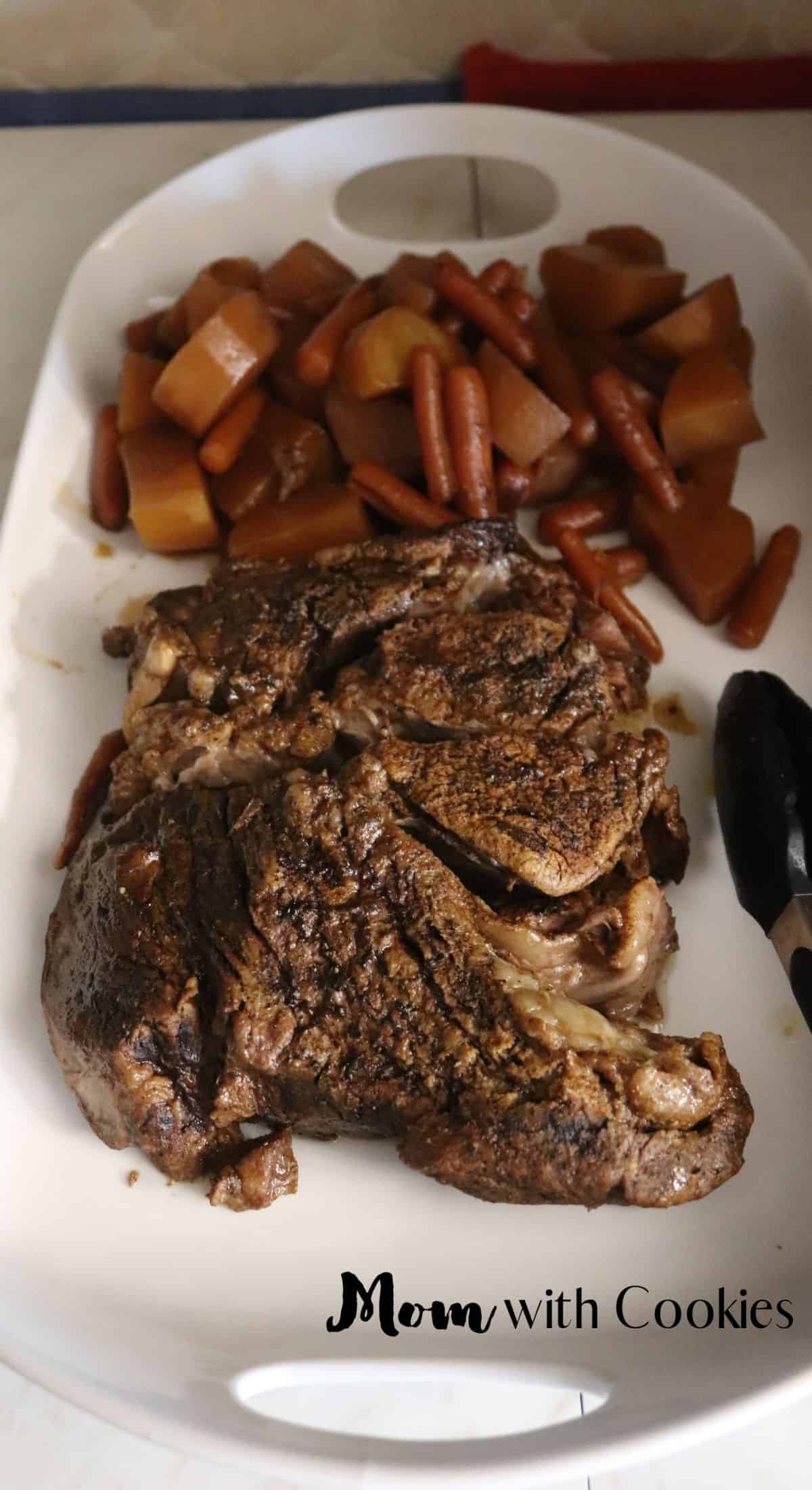 homemade pot roast on a serving tray with cooked potatoes and carrots