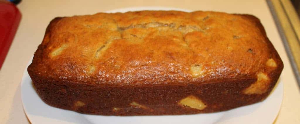 The loaf of pineapple banana bread placed on a plate and ready to eat.