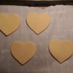 uncooked sugar cookies that have been rolled out and cut into hearts