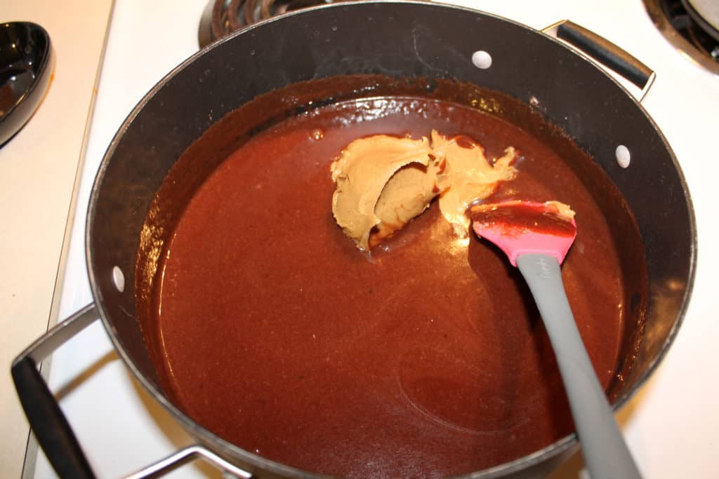 Creamy peanut butter added to the cocoa mixture using a rubber spatula.
