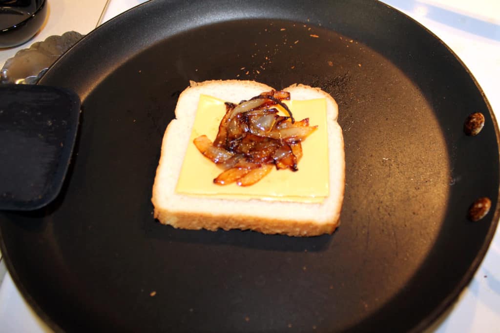 Assembling the grilled cheese on a frying pan.