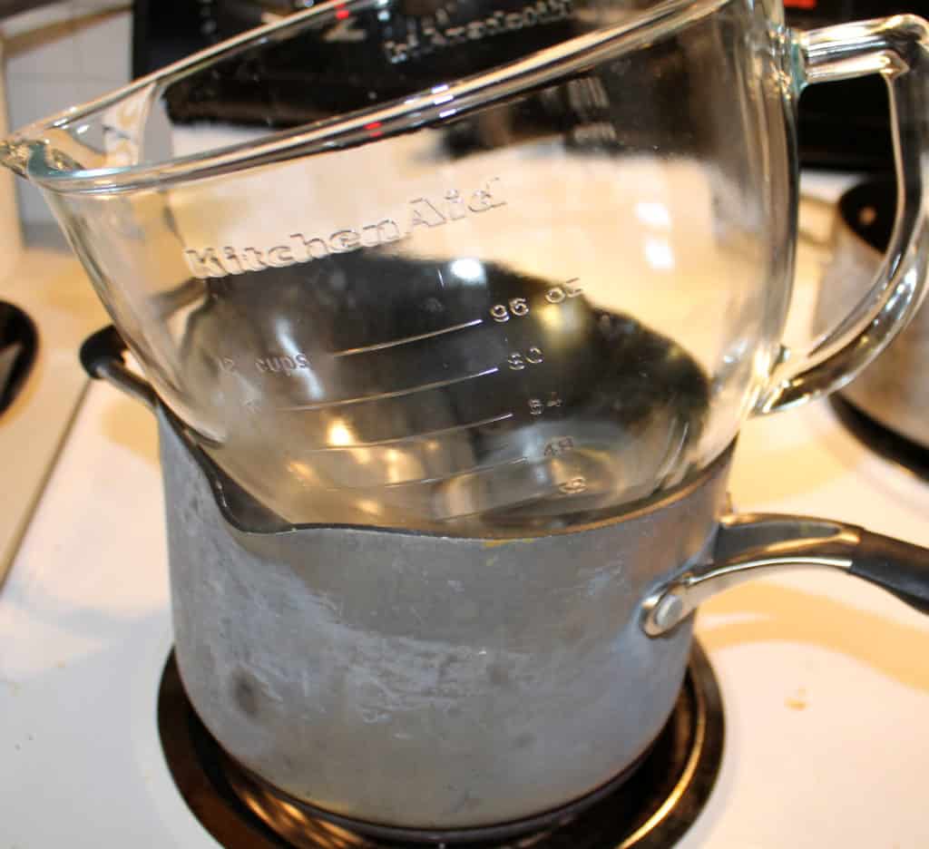 a glass bowl on top of a pan with boiling water