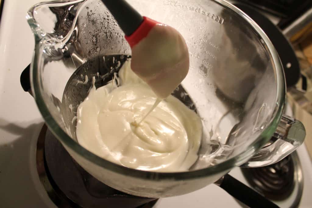 white chocolate that has melted in the glass bowl over the pan with boiling water