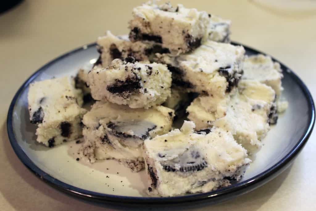 Cooled and sliced oreo white chocolate fudge all stacked on a blue and white plate