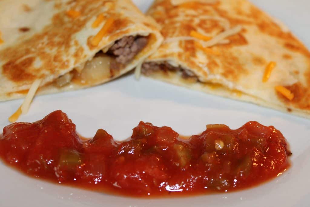 sliced cheeseburger quesadillas on a plate with salsa