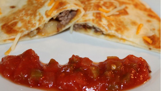 sliced cheeseburger quesadillas on a plate with salsa