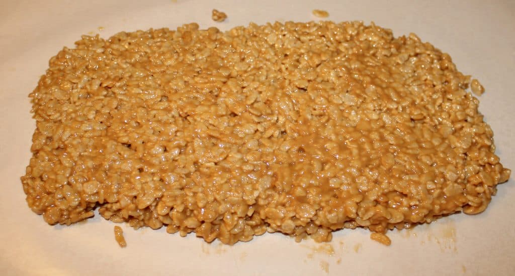 Peanut butter rice crispy treats layed out on wax paper to cool