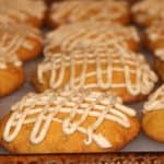 a plate of soft pumpkin cookies with brown butter icing drizzled on top