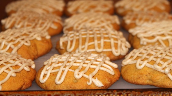 a plate of soft pumpkin cookies with brown butter icing drizzled on top