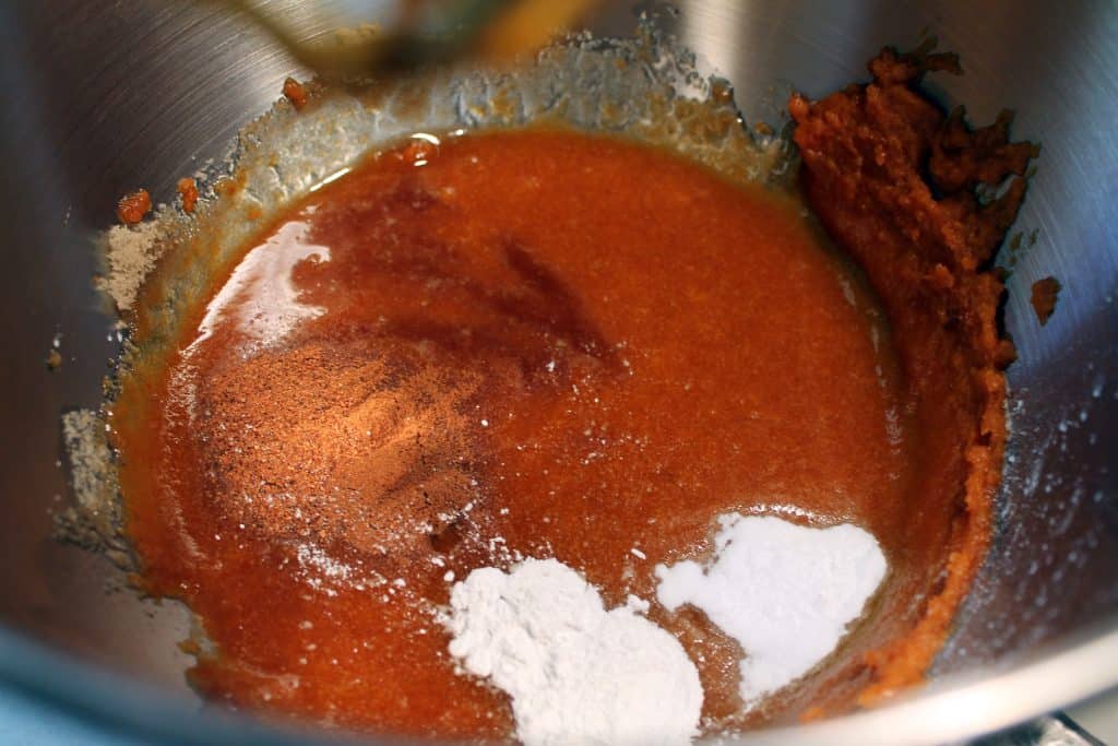 Adding cinnamon nutmeg, baking soda, and baking powder to the pumpkin mixture.