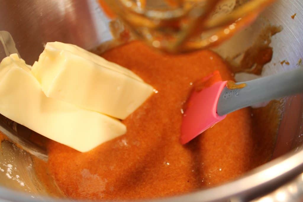 Adding softened butter to the pumpkin mixture.