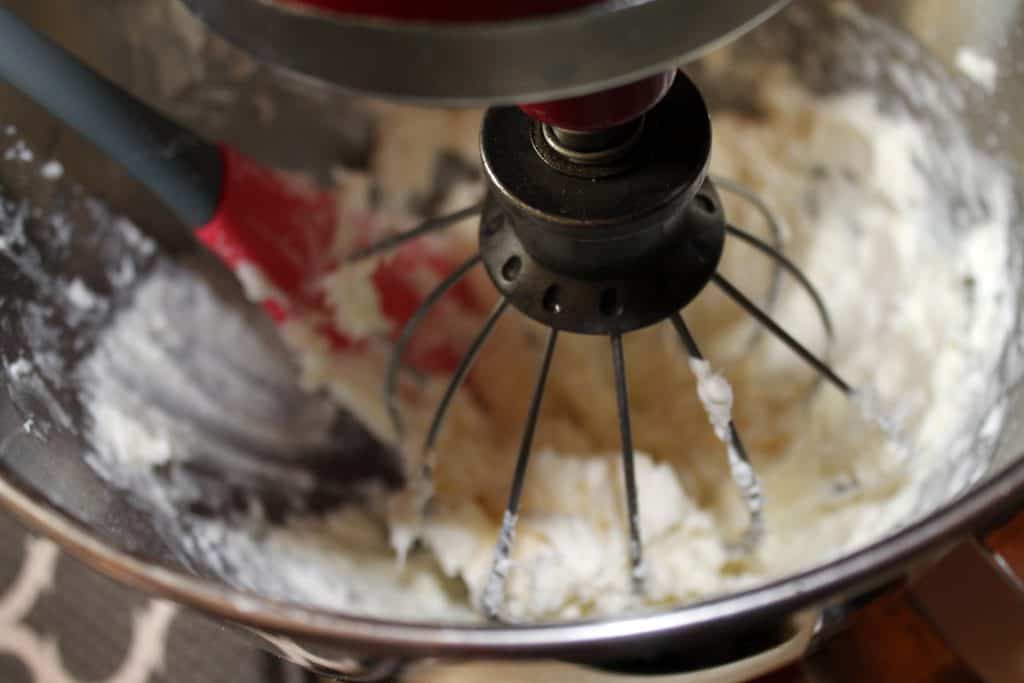 Whisking the powdered sugar and cream cheese together in a mixing bowl