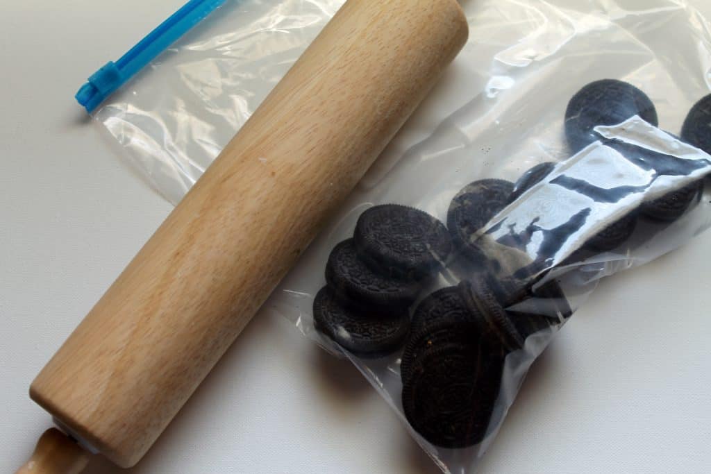 Oreos in a bag with a rolling pin beside them.