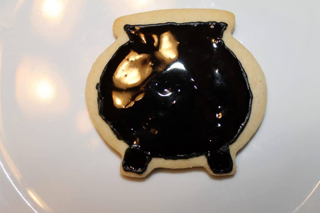 Fill in the cauldron cookie with black royal icing that is flooding consistency.