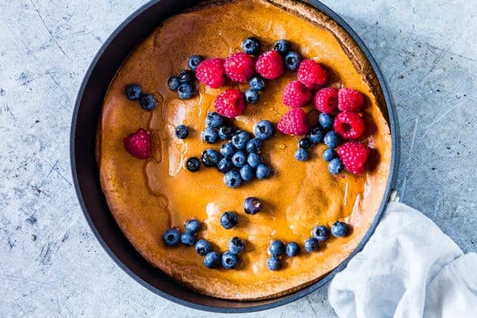 a pumpkin pancake topped with blueberries and raspberries