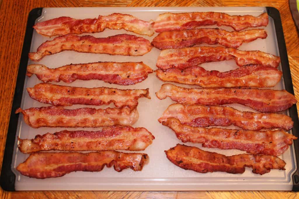 a cutting board with a bunch of cooked bacon