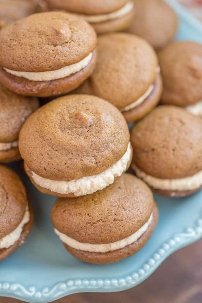 a bunch of pumpkin whoopee pies on a light blue serving tray