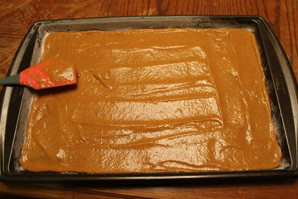 spreading the pumpkin batter into the prepared cookie sheet
