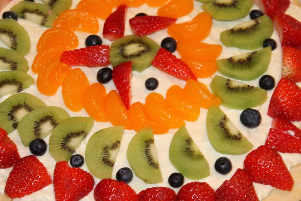 Fruit pizza decorated with lots of fruit.