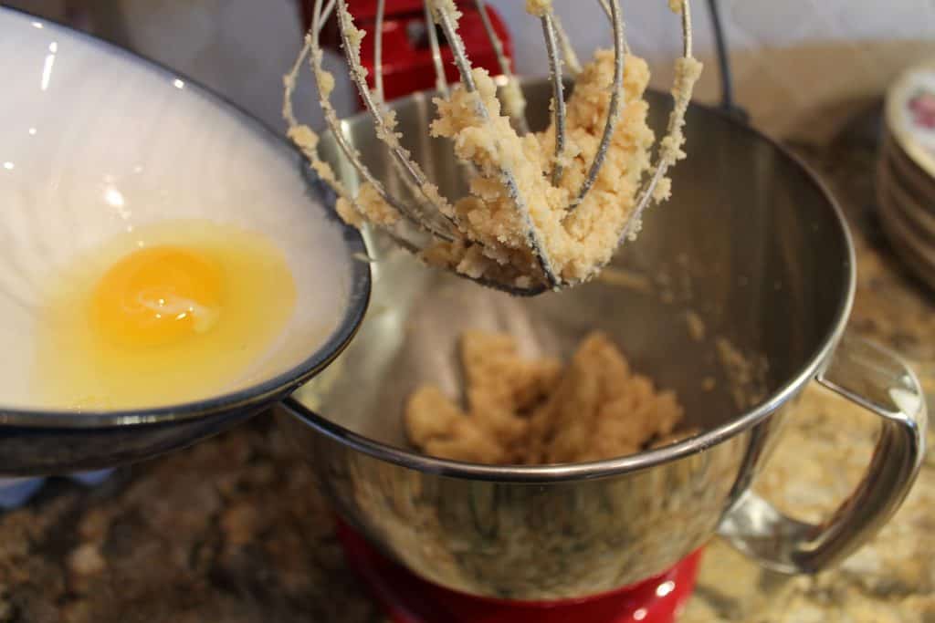 adding egg to the mixing bowl