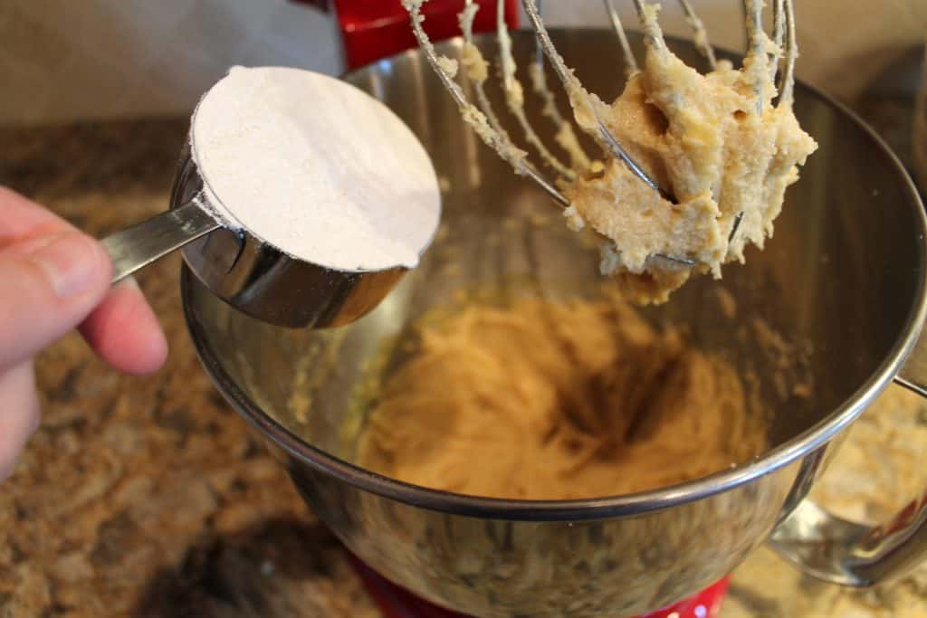 adding flour to the mixing bowl