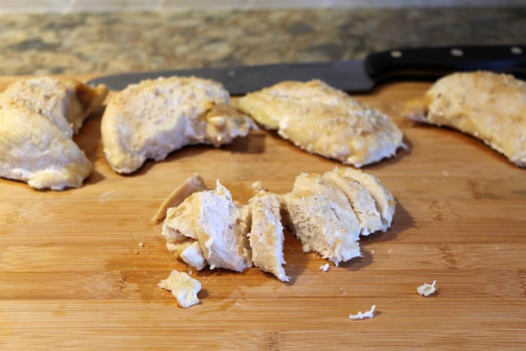 baked chicken cut into pieces on a cutting board