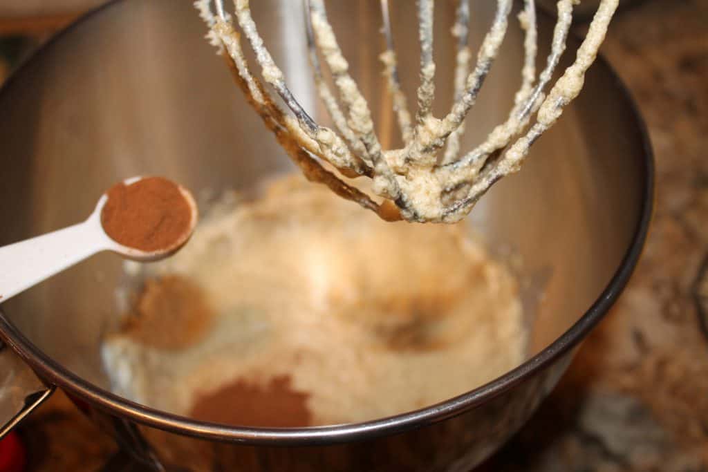 Adding ground cinnamon into the mixing bowl.