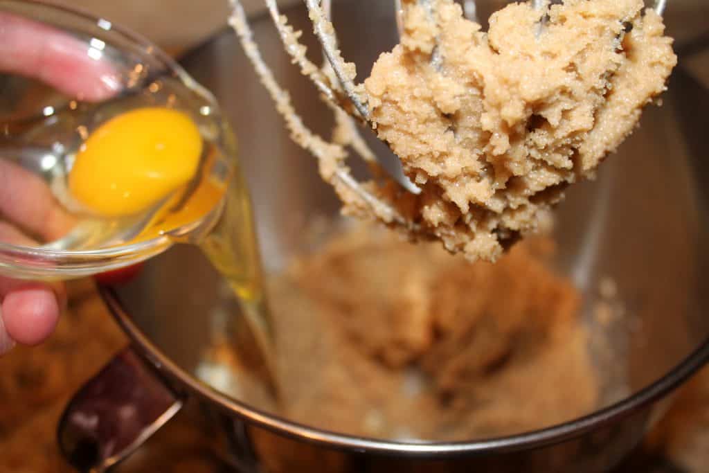 adding egg to the bowl with browned sugar and butter