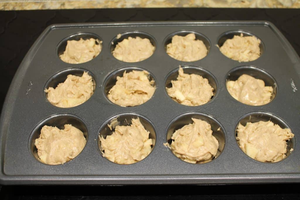 apple batter scooped into a muffin pan