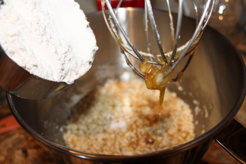 adding flour to the mixing bowl