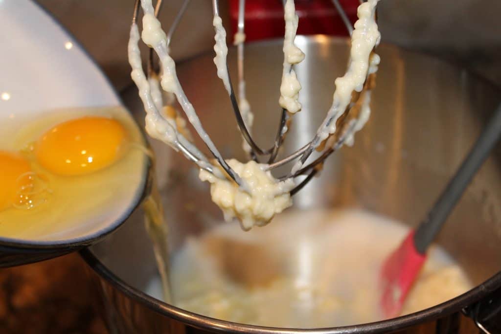 Adding egg into the mixing bowl.