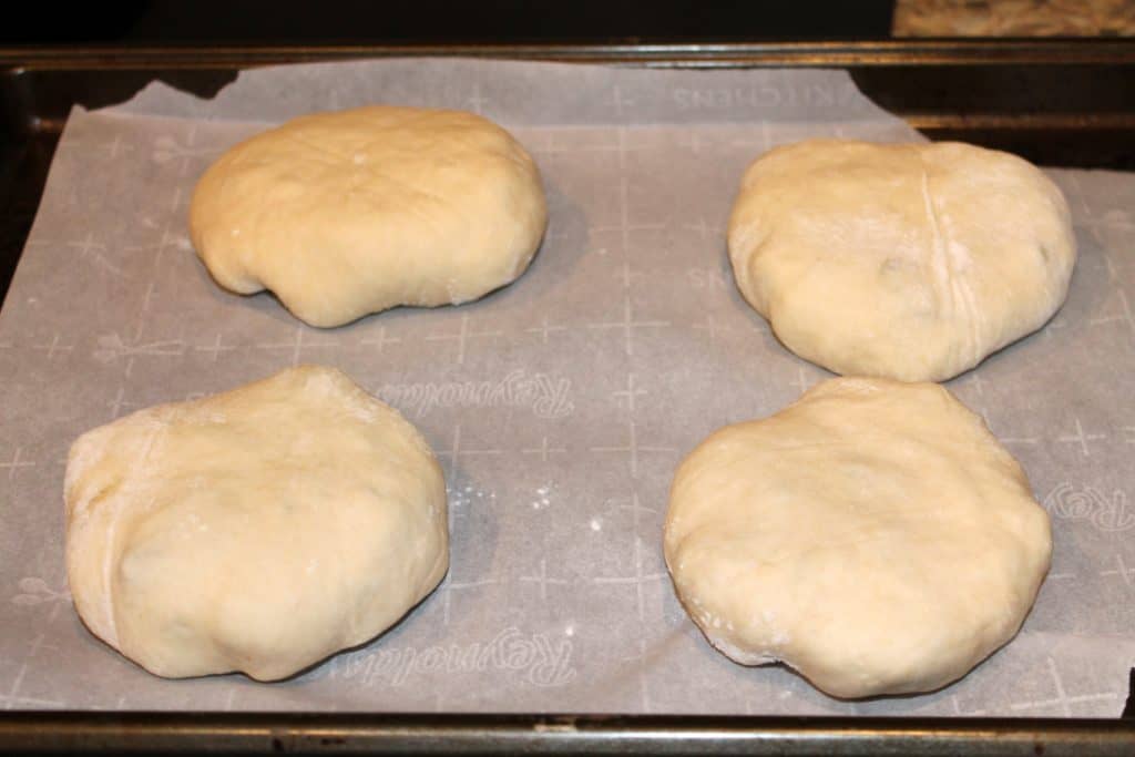 Bierocks on cookie sheet lined with parchment paper ready to be baked.