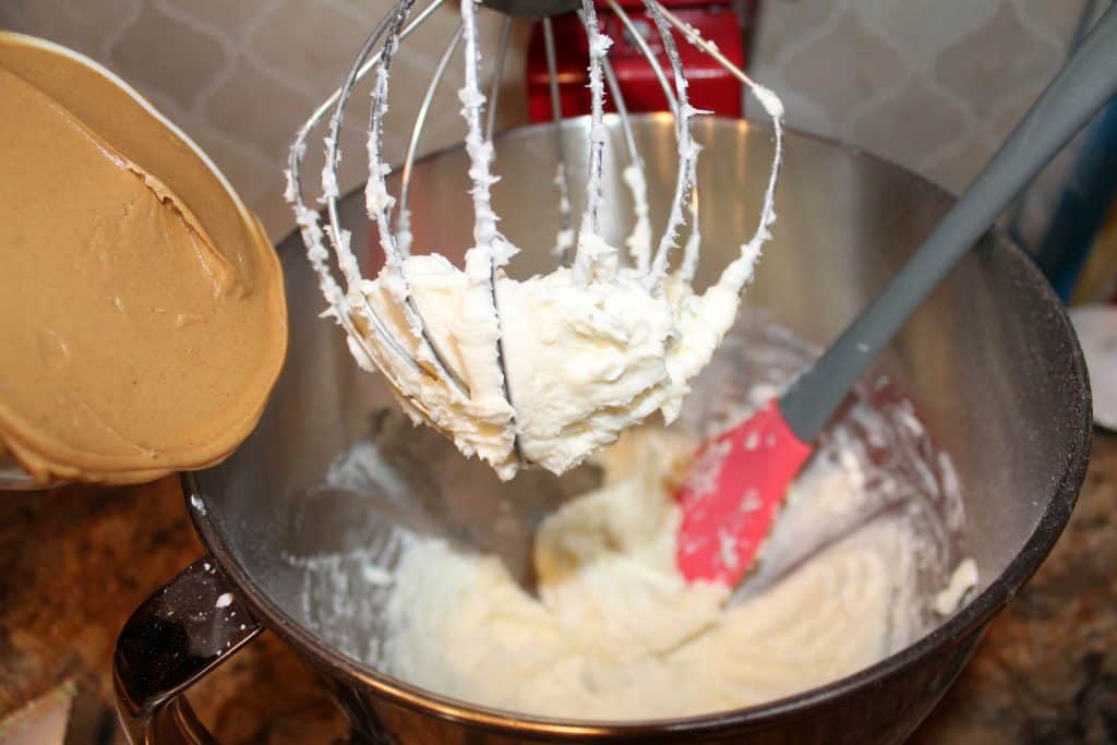 adding creamy peanut butter to the mixing bowl