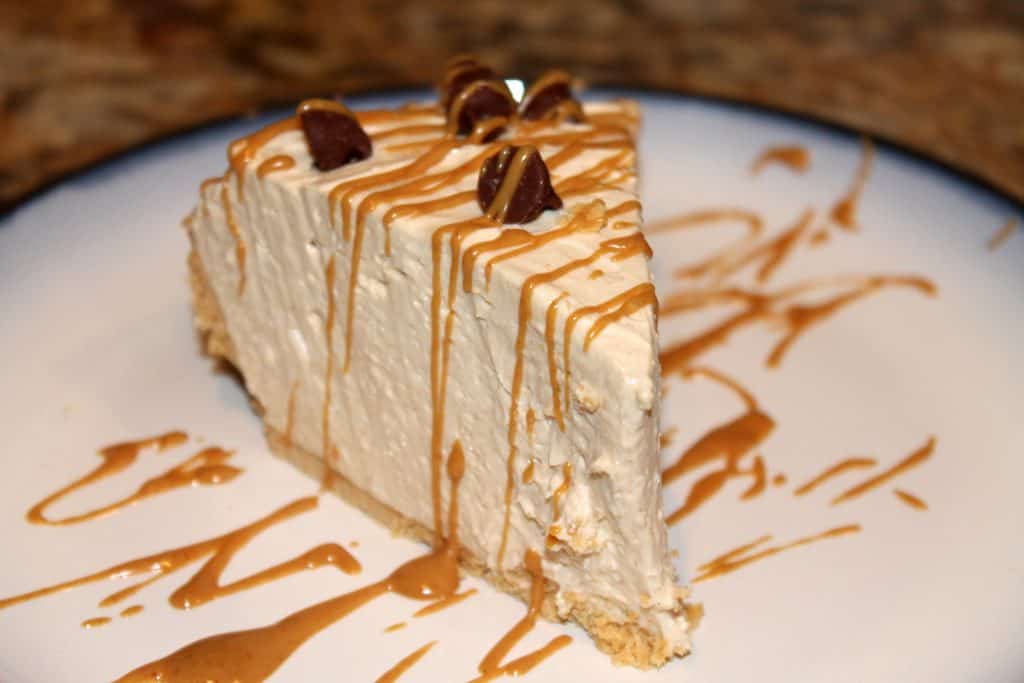 a slice of peanut butter pie with drizzled peanut butter sauce and chocolate chips