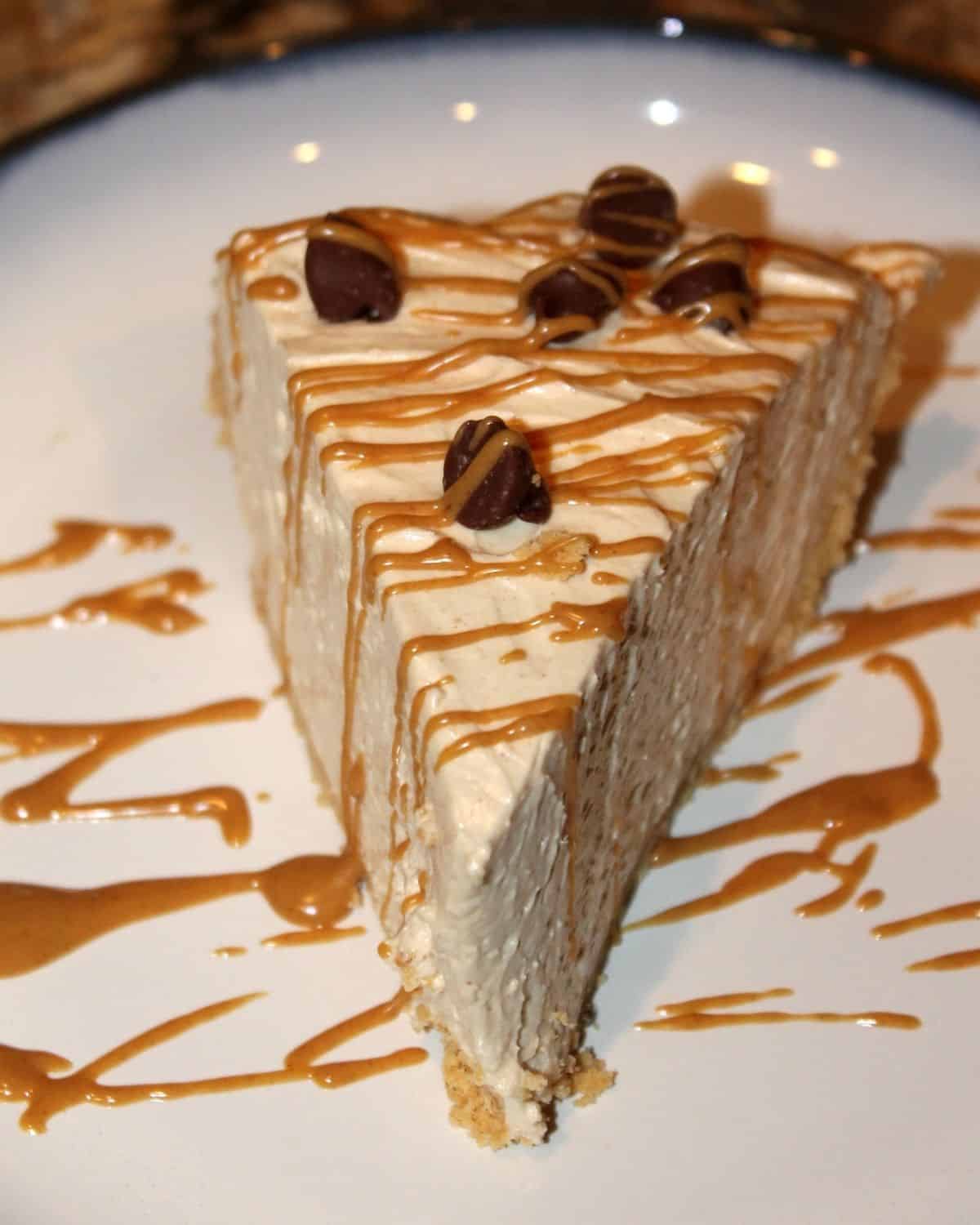 a slice of no bake peanut butter pie with drizzled melted peanut butter on top