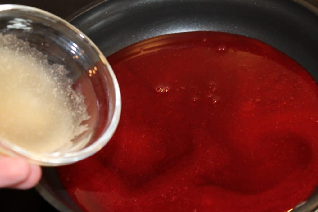 Adding the gelatin to the raspberry sauce.