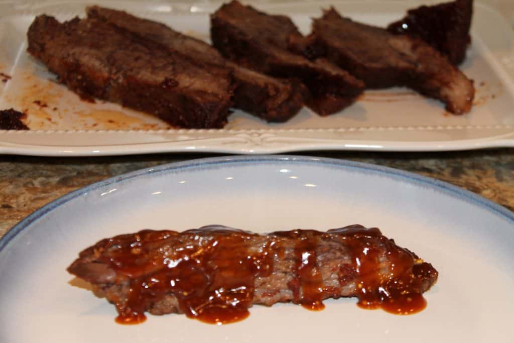 slow cooker brisket with barbecue sauce drizzled on top