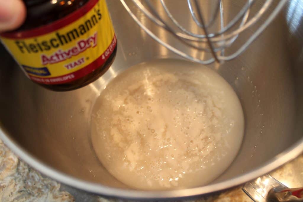 Adding yeast to bowl of warm water