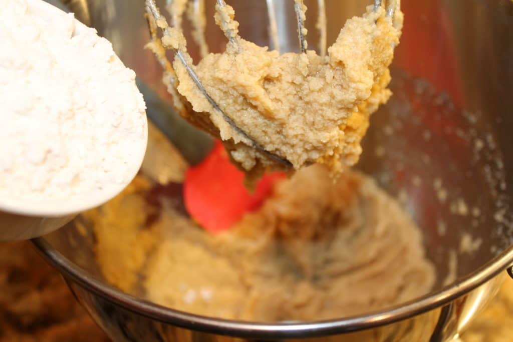 Adding flour to the cookie batter.