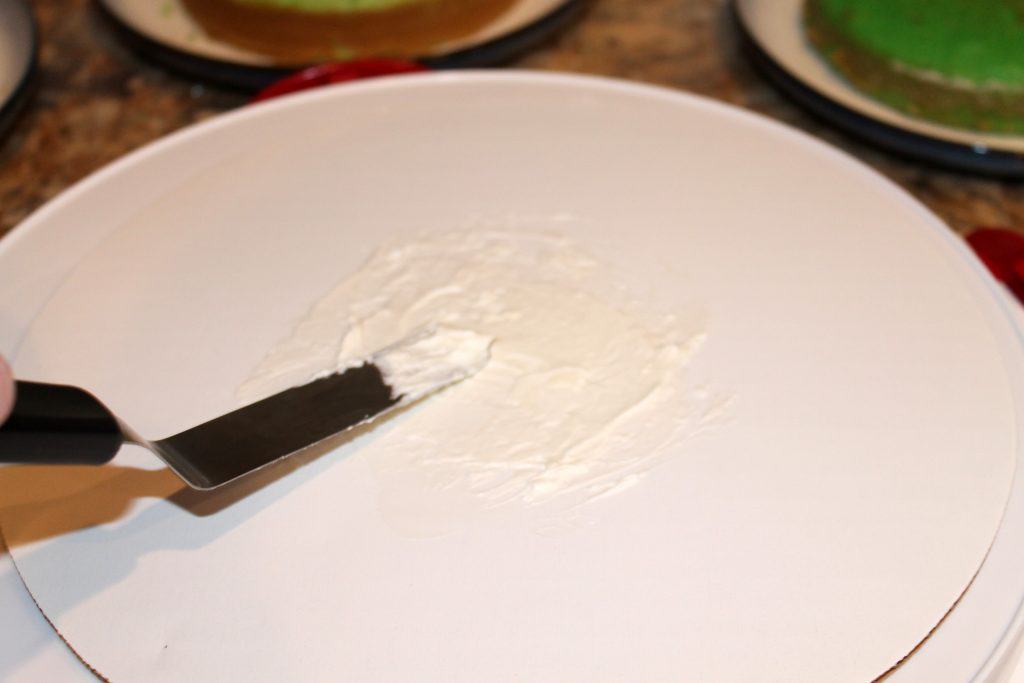 Placing a little icing on a cake circle.