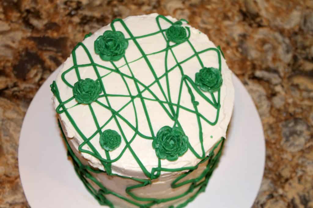 Green layer cake decorated with candy flowers.