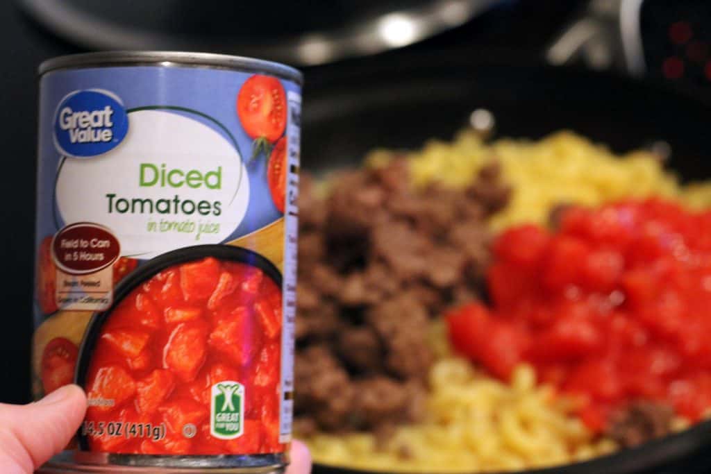 Diced tomatoes, hamburger, and noodles all in one frying pan. 