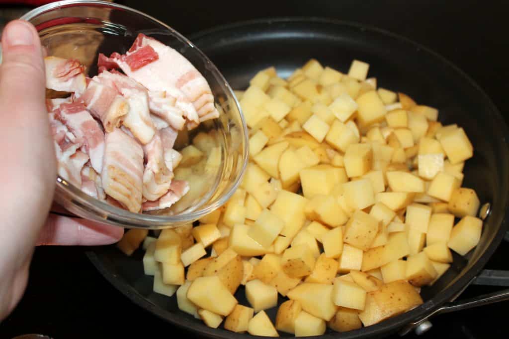 Adding bacon pieces to the breakfast potatoes. 